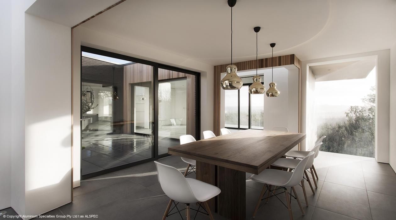 A dining room with a wooden table and white chairs