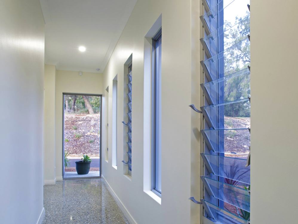 A hallway with white walls and blue windows