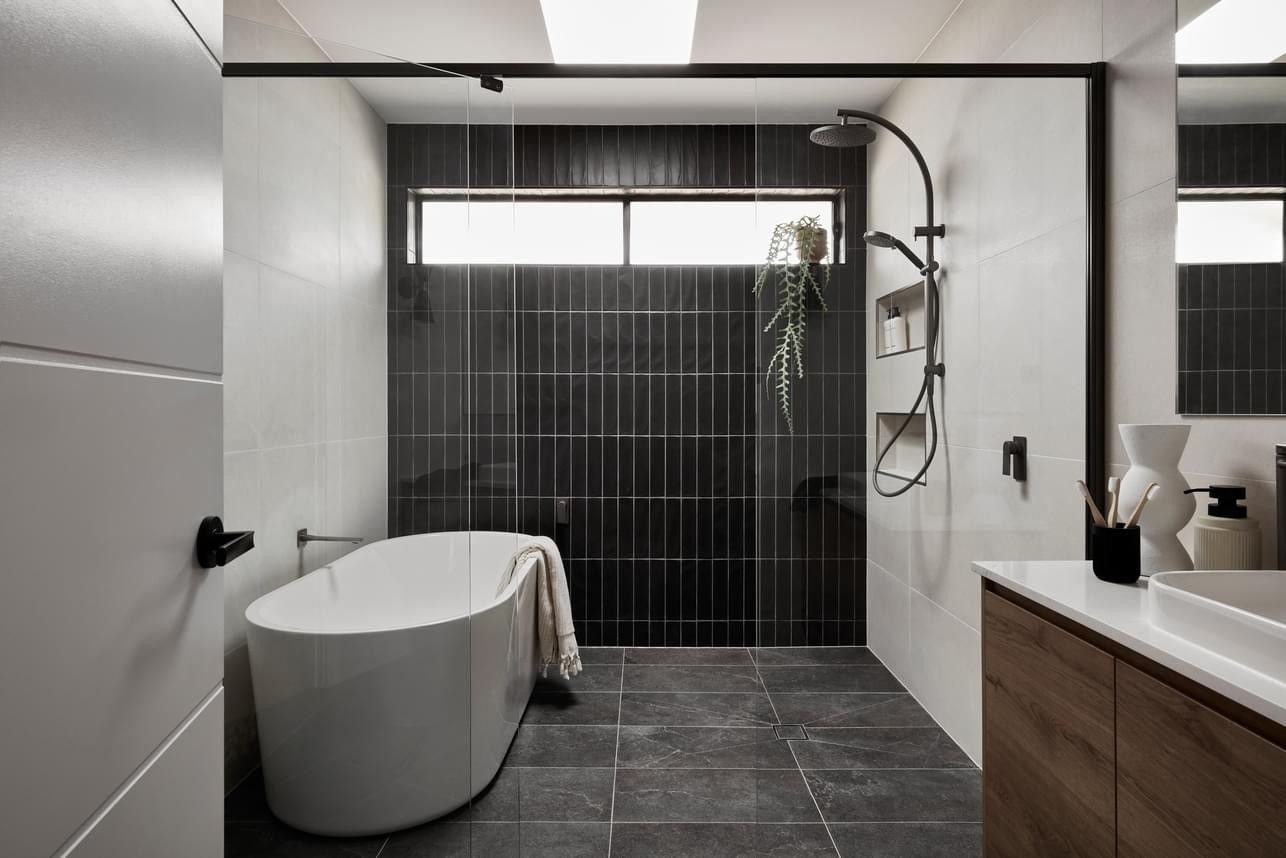 A bathroom with a bathtub , sink , and shower.