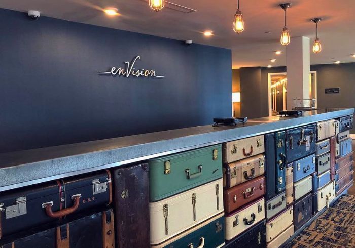 Stylish lobby with a long counter, colorful drawers, hanging lights, and a navy wall logo
