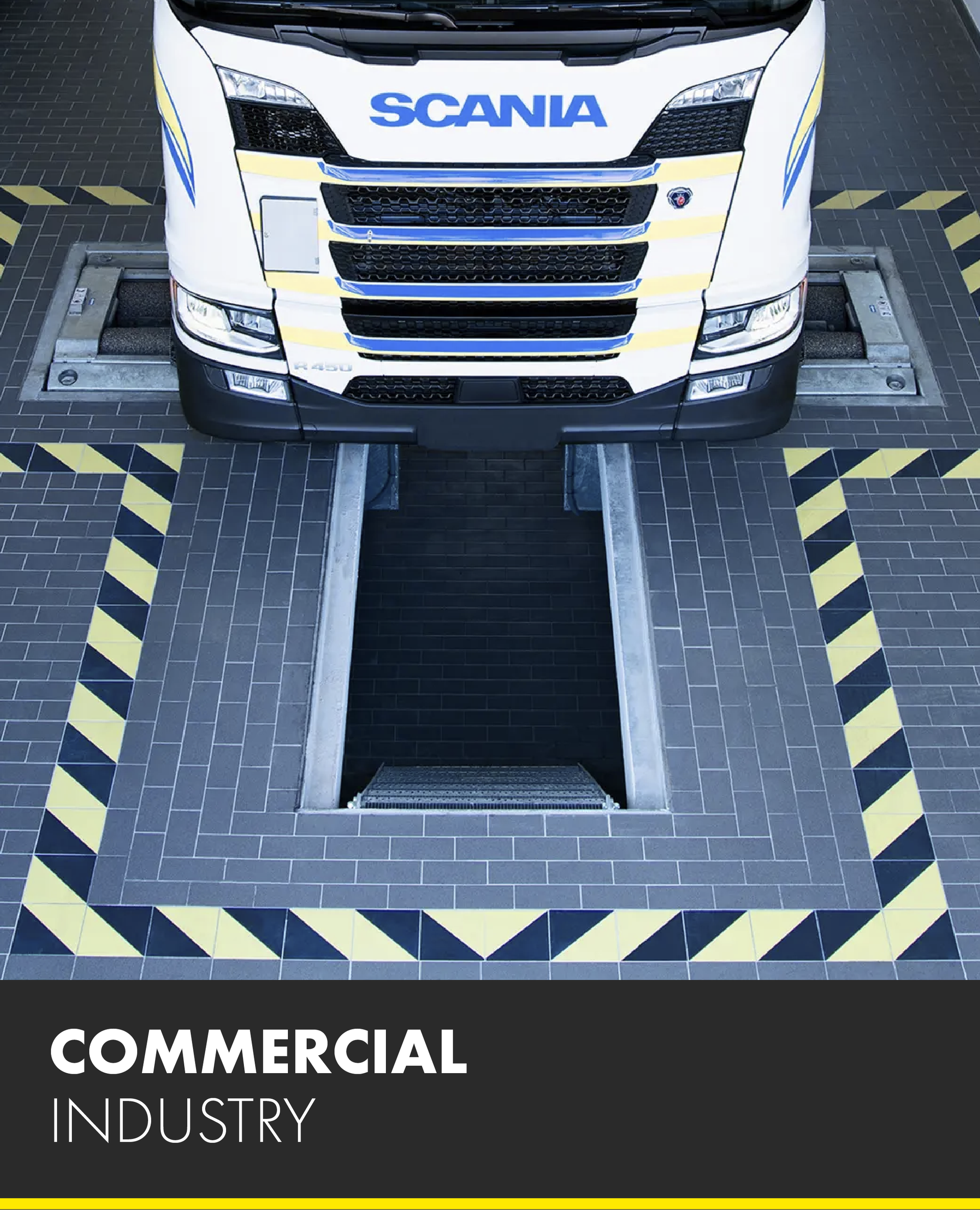 A scania truck is sitting on a lift in a commercial industry