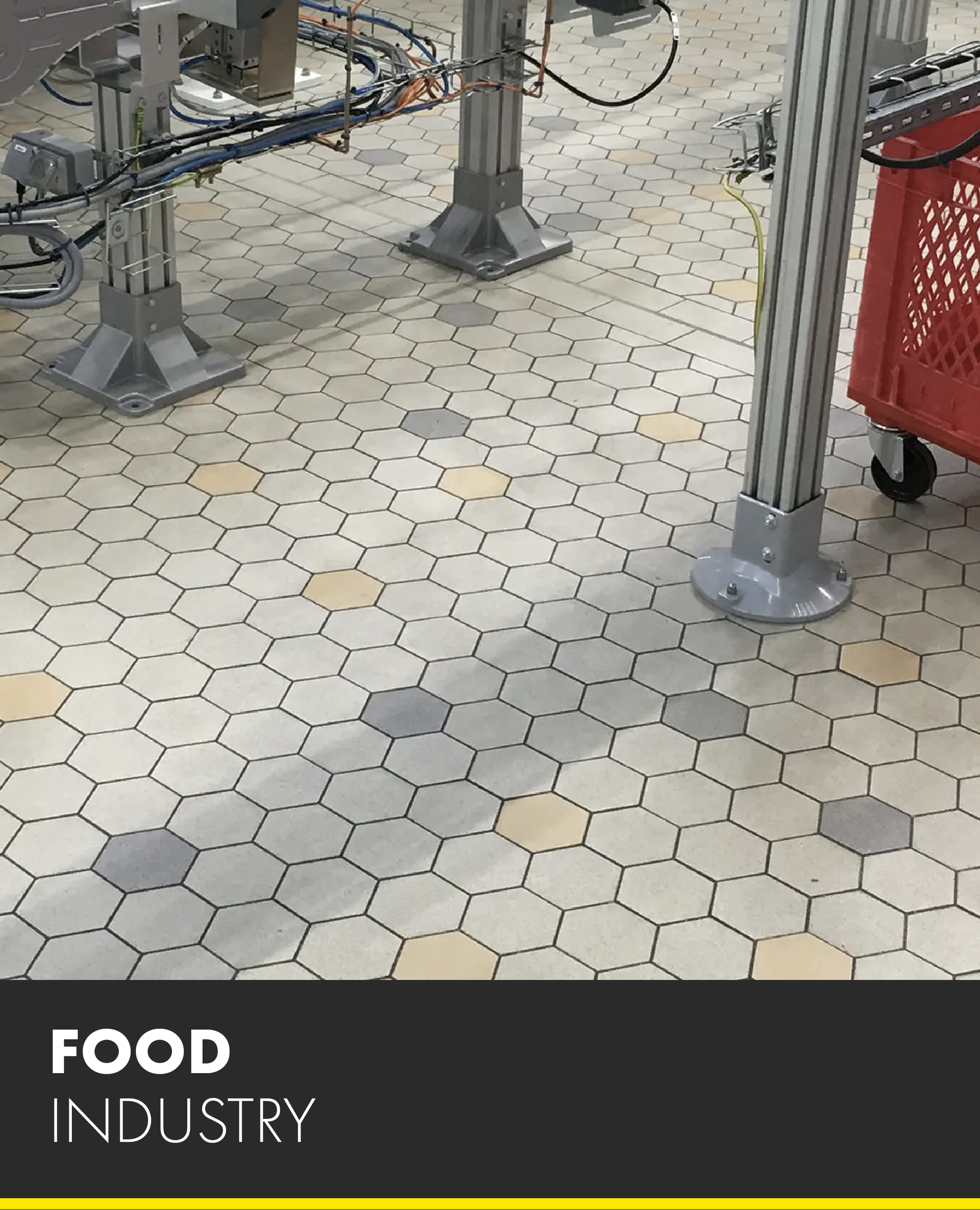 A red cart is sitting on the floor of a food industry factory.