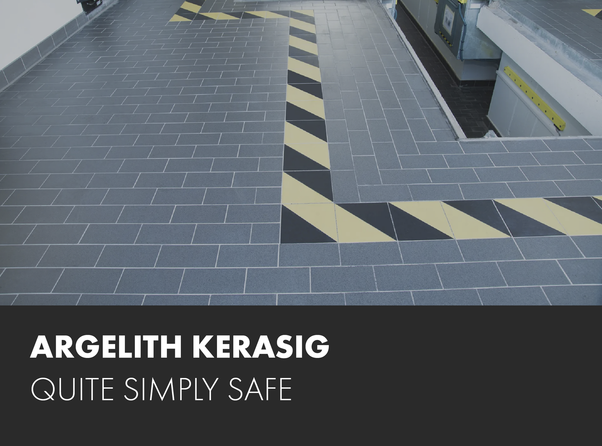 A gray tile floor with yellow and black stripes and the words 
