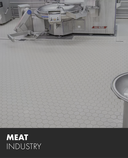 A picture of a meat industry machine on a tiled floor