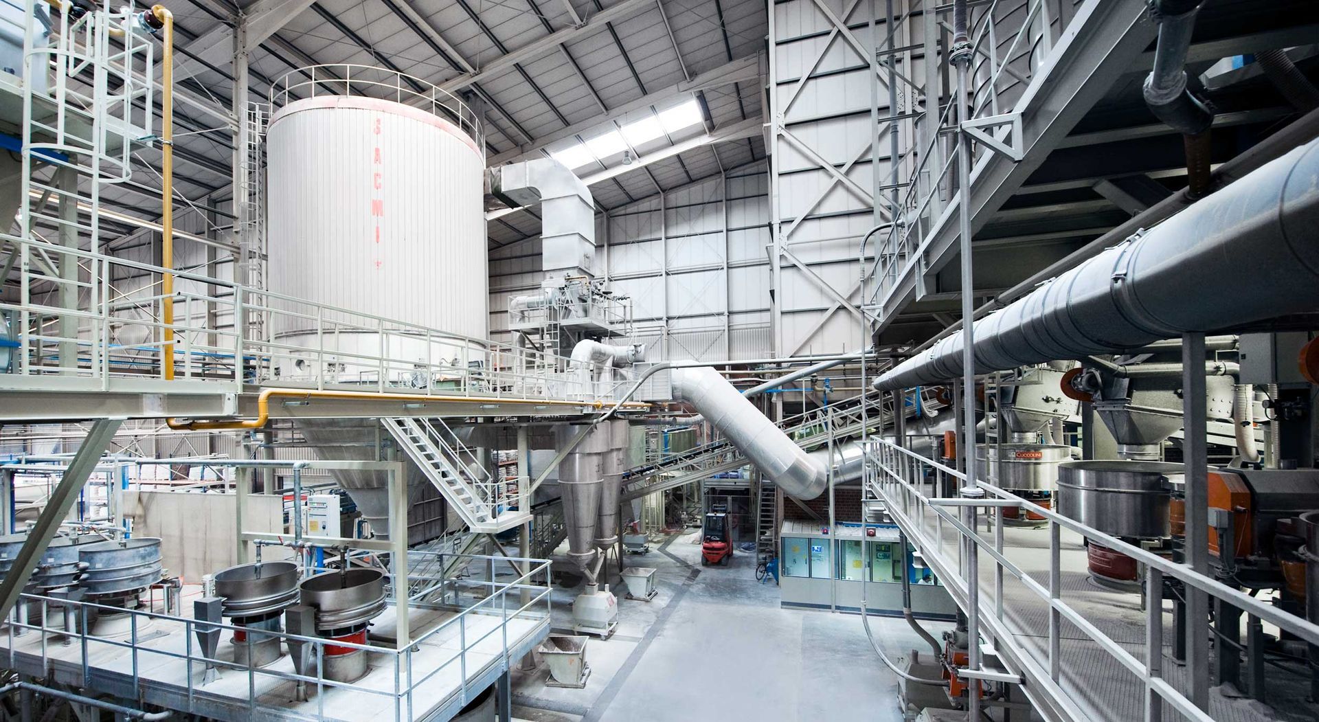 A large warehouse filled with lots of machinery and pipes.