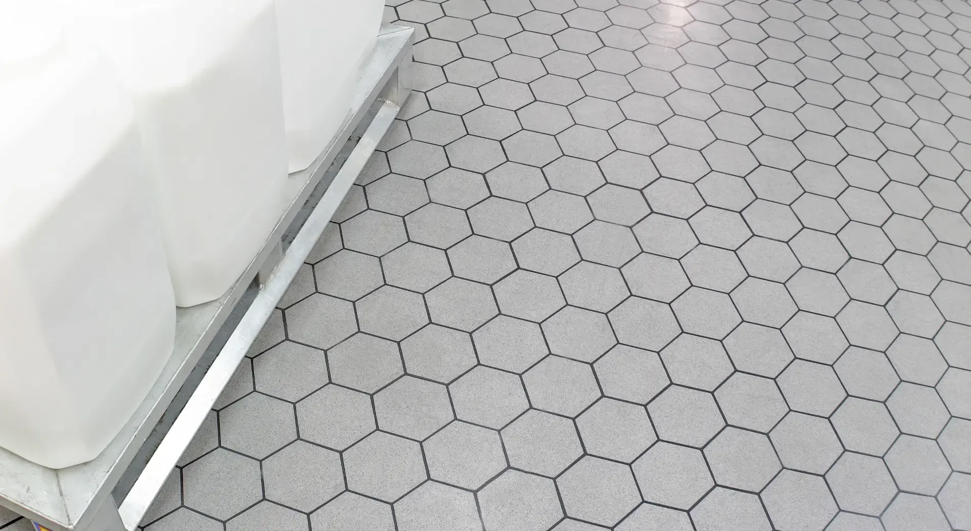 A white couch is sitting on a tiled floor with a hexagon pattern.