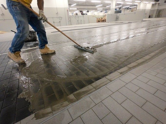 A man is cleaning a tiled floor with a mop