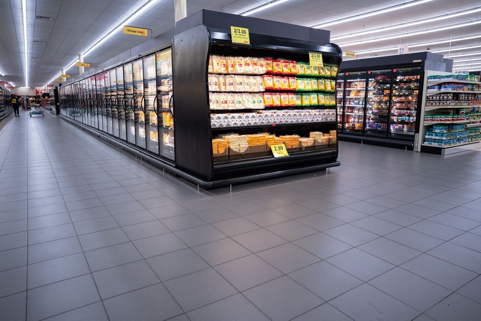 Grocery store aisle with refrigerated food cases.