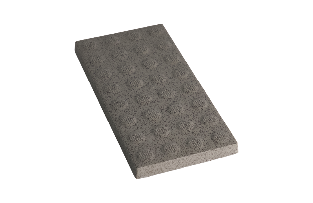 A grey, rectangular concrete paver with a textured, studded surface for tactile ground guidance.