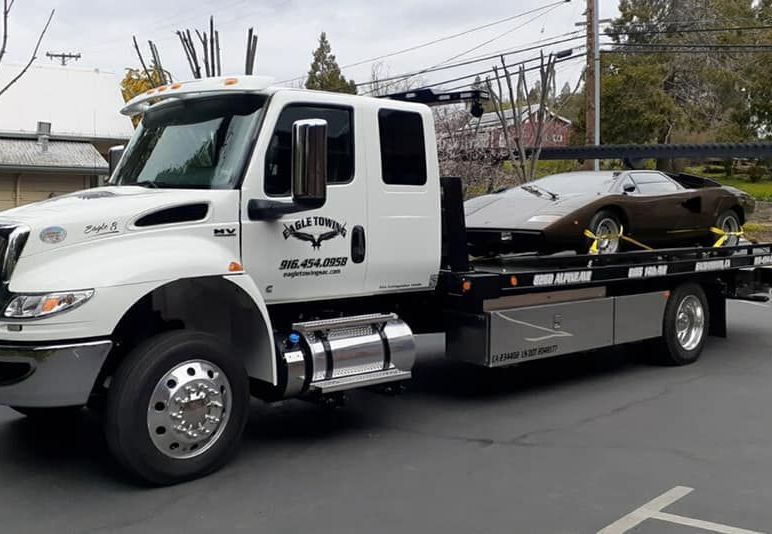 Eagle Towing Truck with White Car on the Back — Lockouts in Sacramento, CA Eagle Towing Truck with White Car on the Back — Lockouts in Sacramento, CA