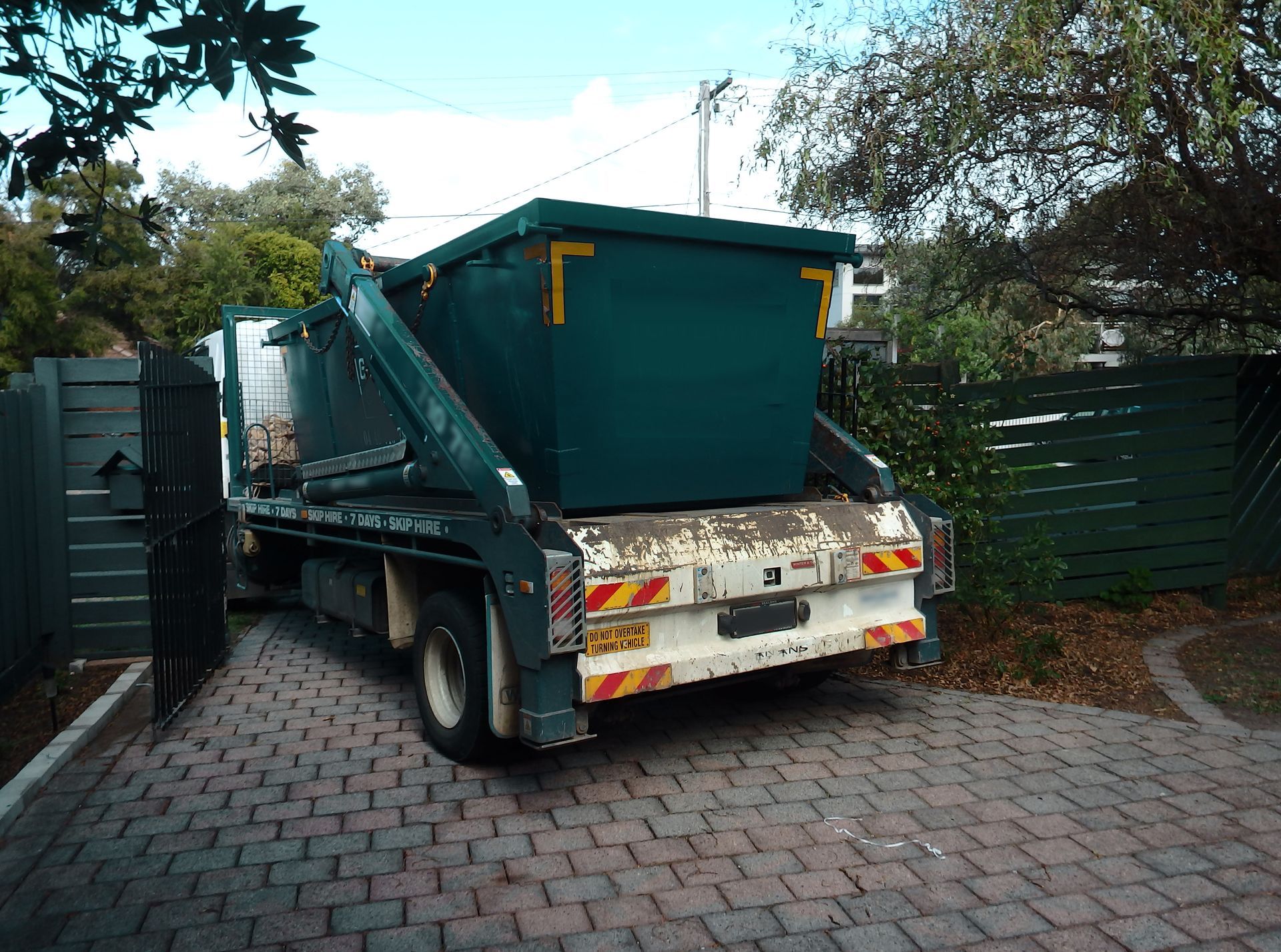 The back view of a skip being delivered on a truck.