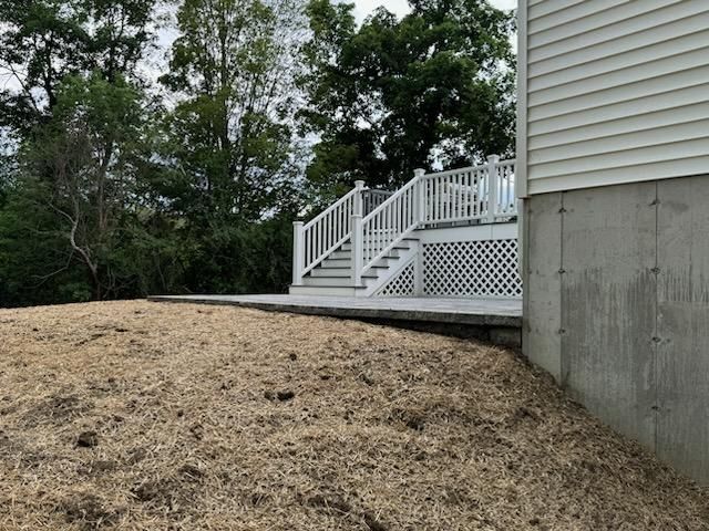 A White House With A Deck And Stairs On The Side Of It | Husdon Valley, NY | Bastian Lawn and Landscape, LLC