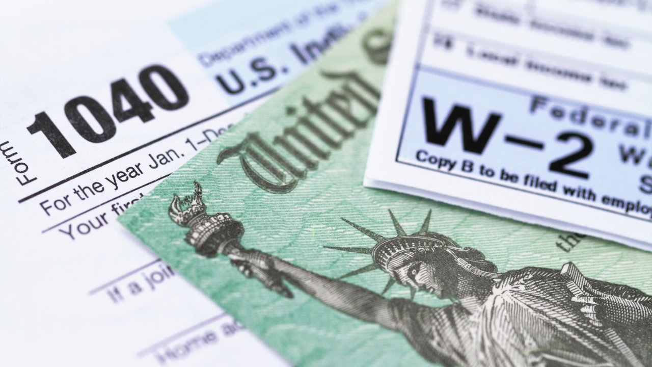 U.S. Form 1040, a W-2 tax form, and a government tax refund check featuring the Statue of Liberty.