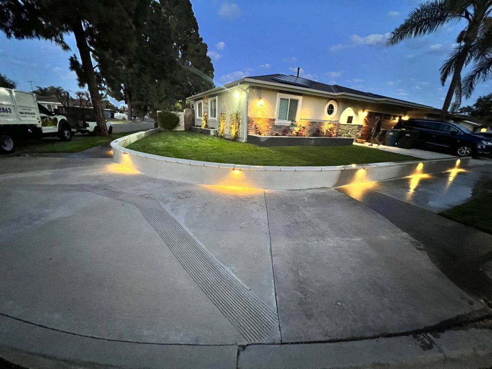 Illuminated suburban house with lit walkway and driveway at dusk