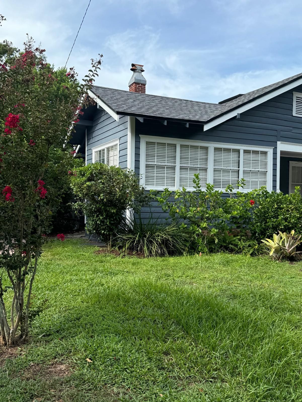 A small house with a large lawn in front of it.