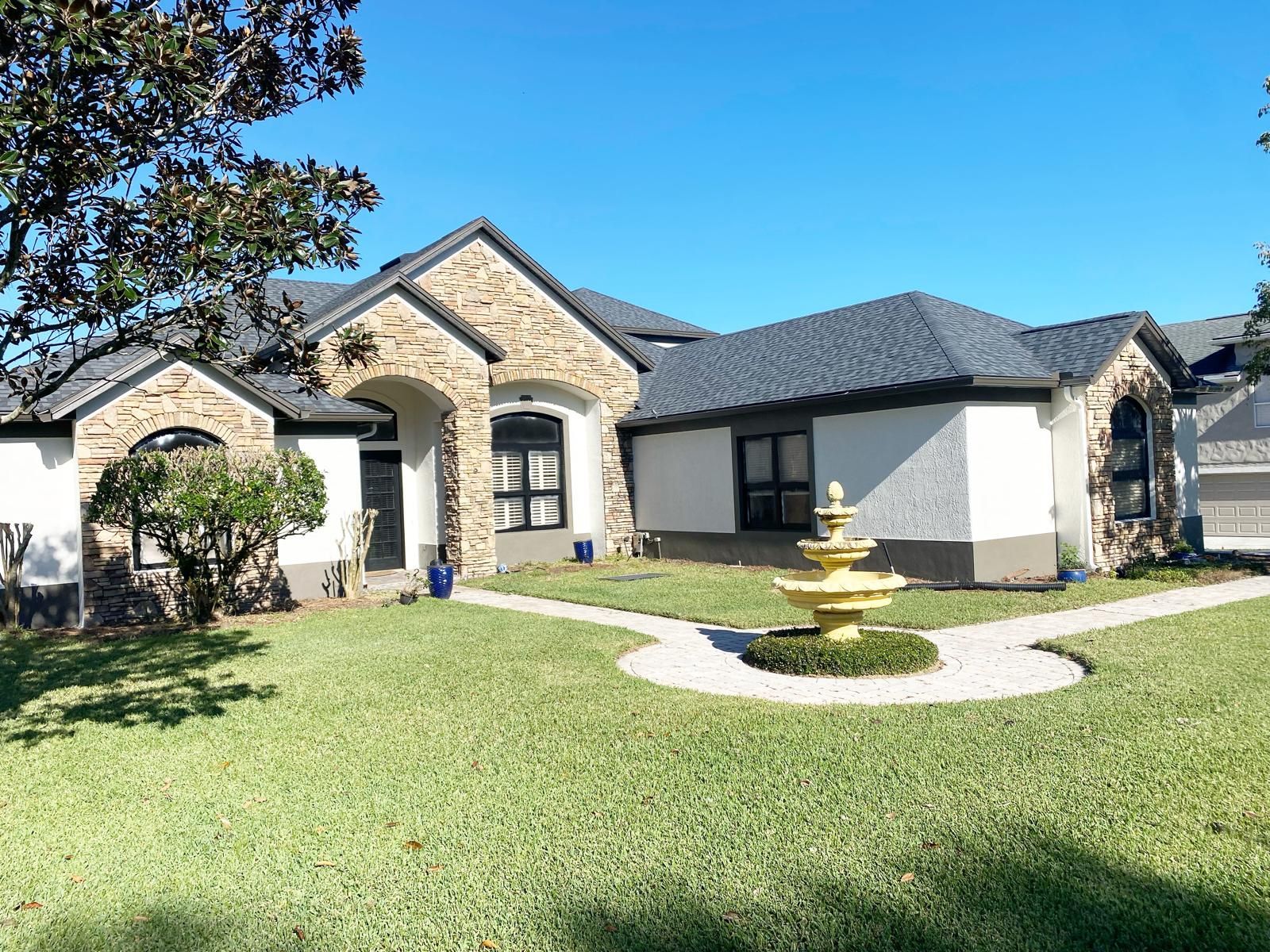A large house with a fountain in front of it.