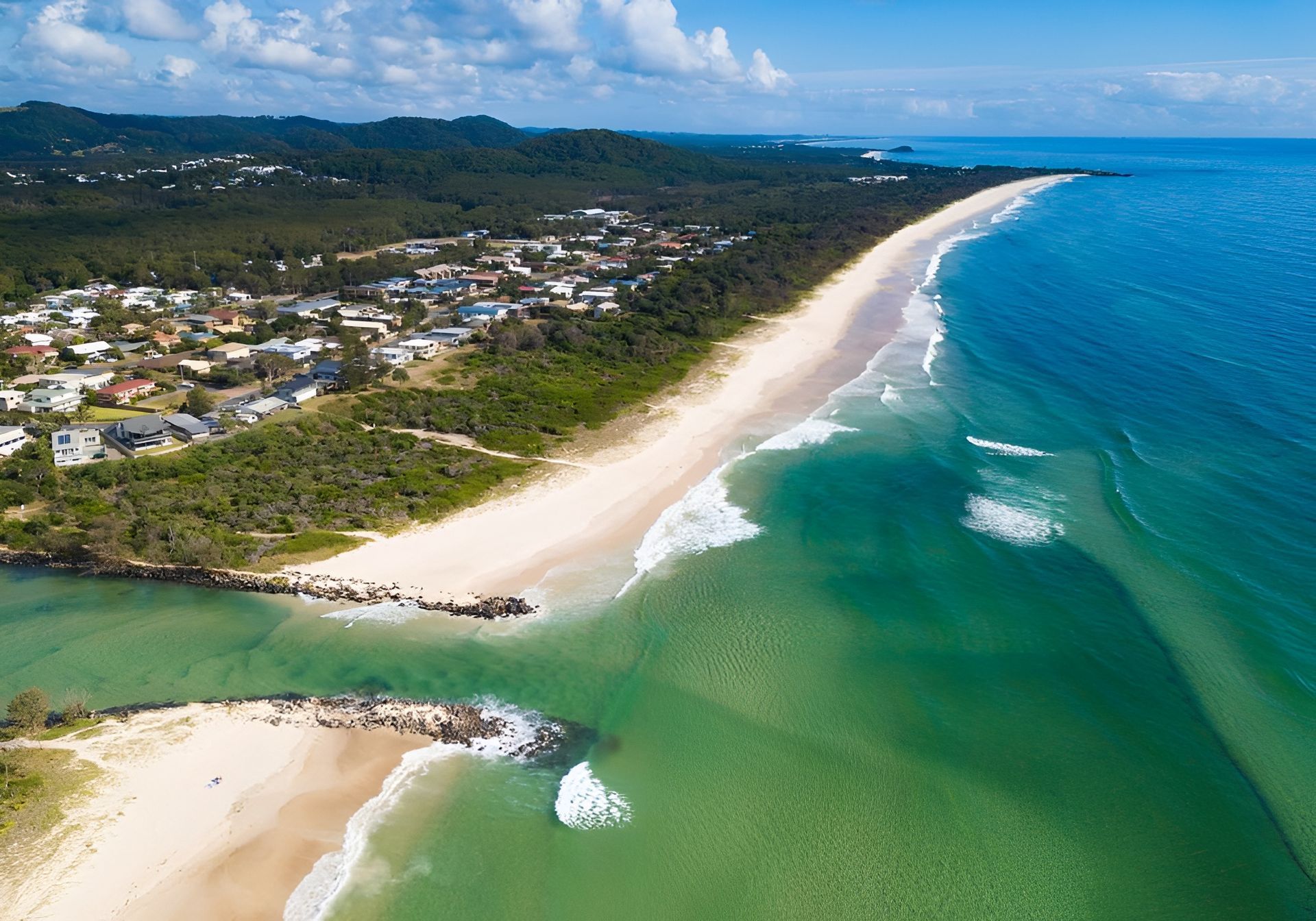Aerial View of a Beach With White Sand, Turquoise Water, and a Residential Area — Intolec Electrical In Pottsville, NSW