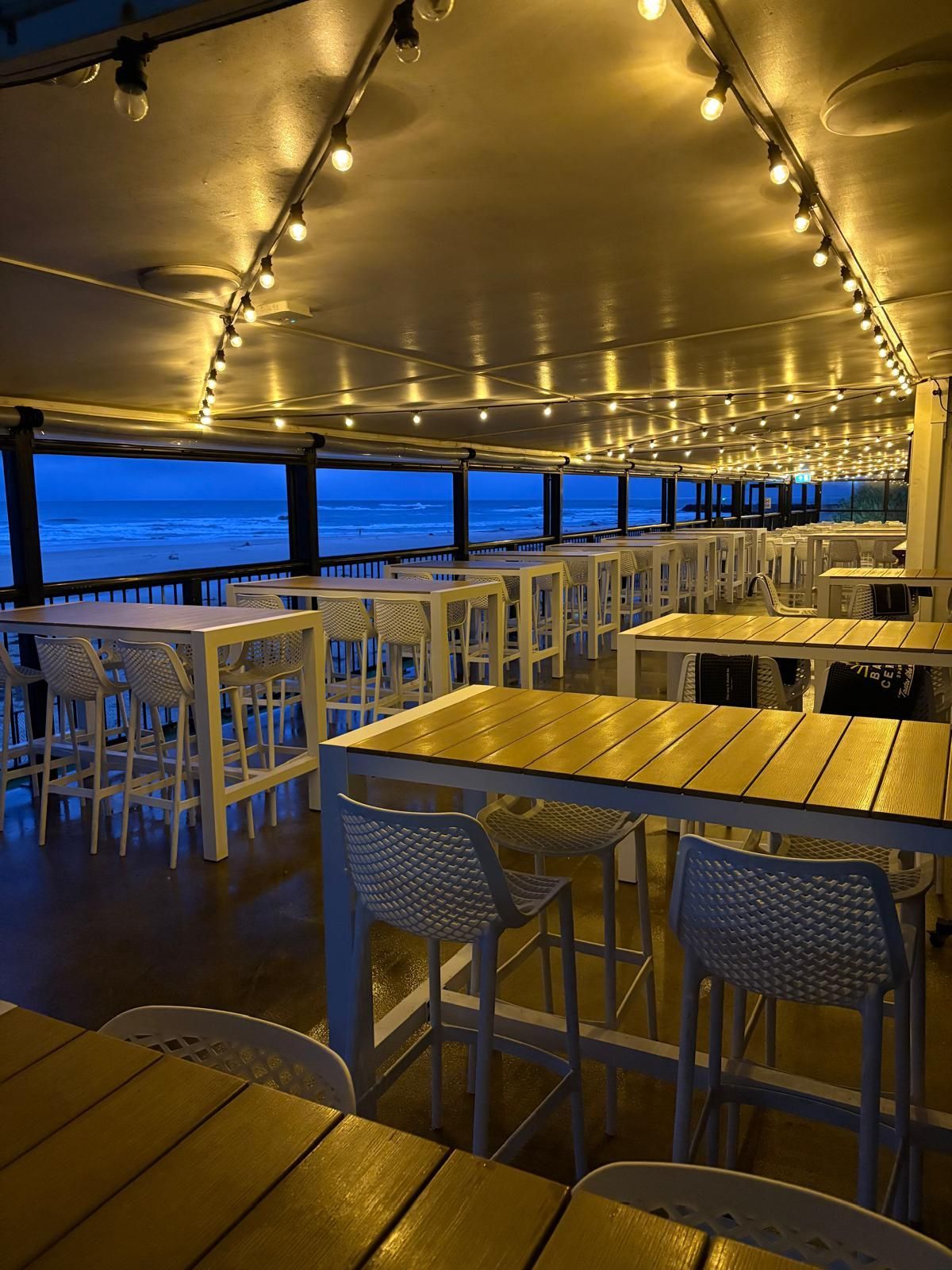 Outdoor Restaurant Seating at Dusk, String Lights Illuminate Tables — Intolec Electrical in Tweed Heads, NSW