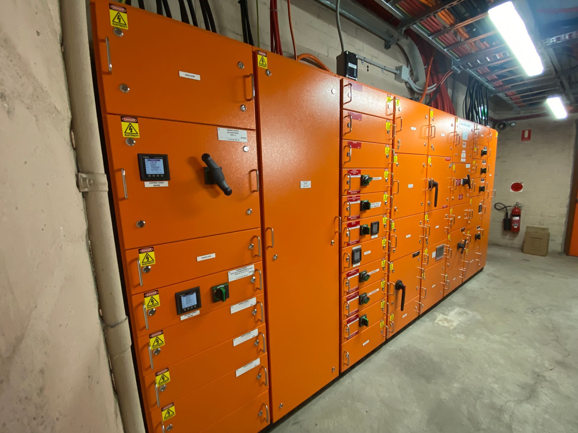Orange Electrical Control Panel in a Room With Cables and Lighting — Intolec Electrical in Tweed Heads, NSW