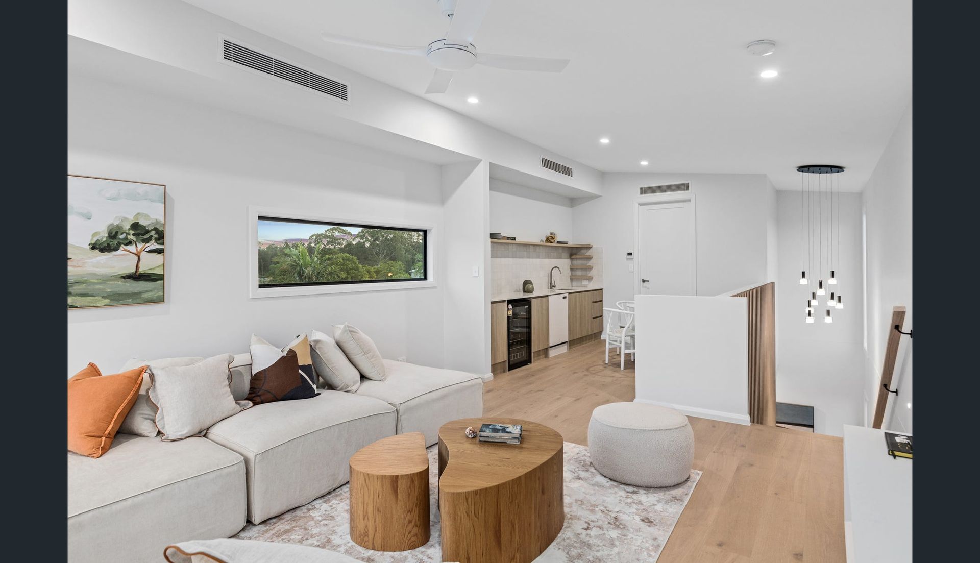 Modern Living Room With White Walls, a Sectional Sofa, and Wooden Coffee Tables — Intolec Electrical in Tweed Heads, NSW
