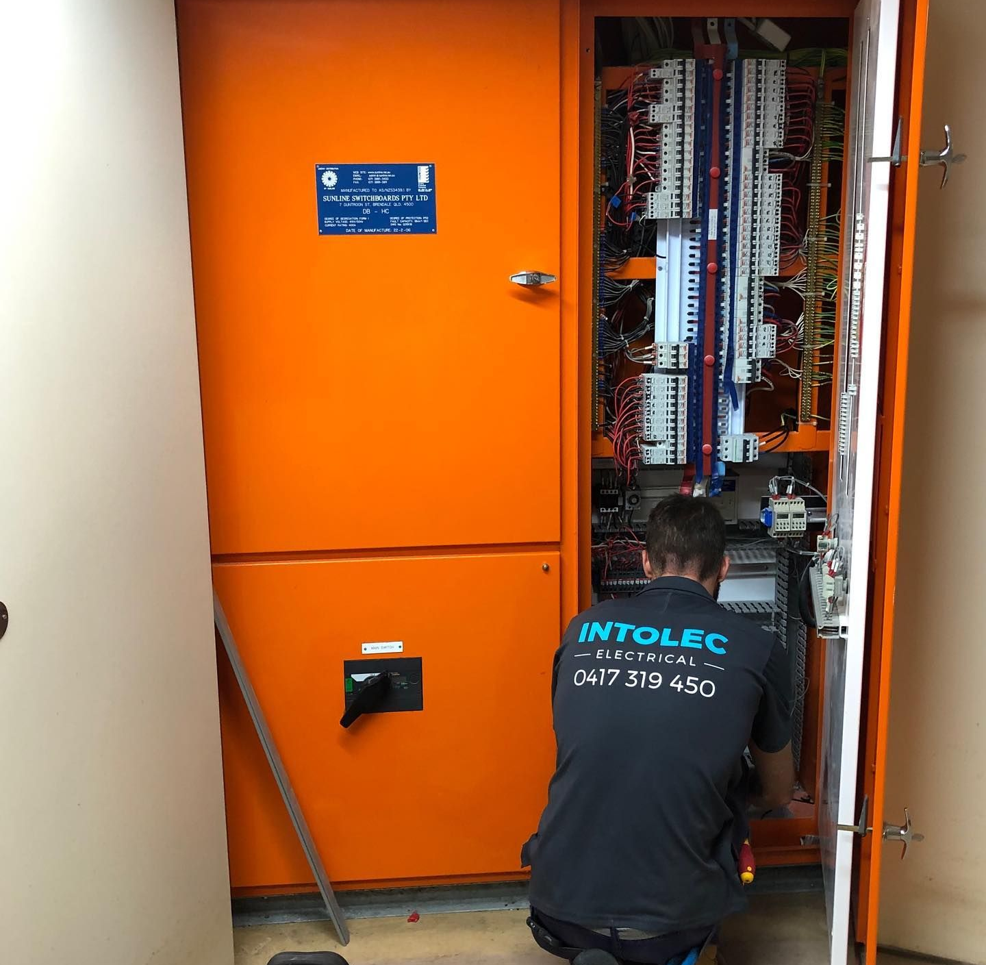 A Person Wearing Red Gloves Uses a Screwdriver — Intolec Electrical In Tweed Heads, NSW
