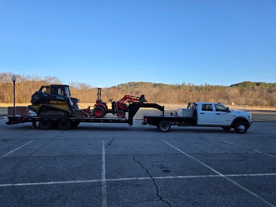 Tow truck hauling an overturned car on a flatbed in a parking lot