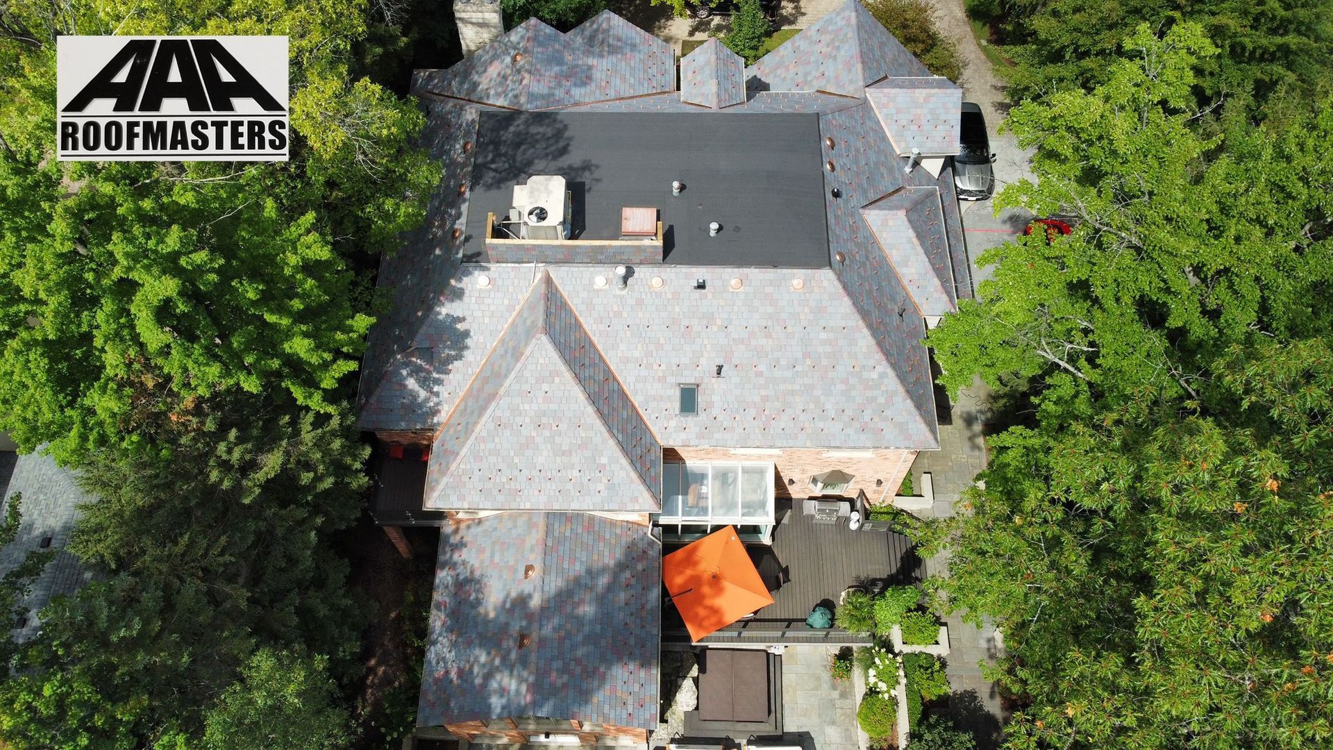 An aerial view of a house with a logo for aaa roofmasters