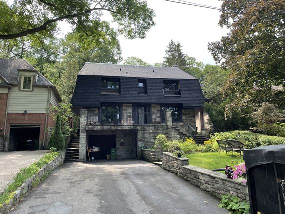 A large house with a black roof and a garage