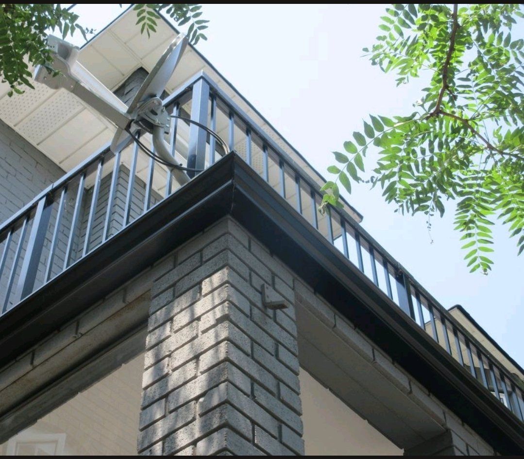 The corner of a house with a balcony and a chimney