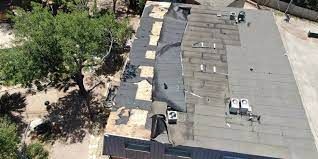 An aerial view of a roof of a building with trees in the background.