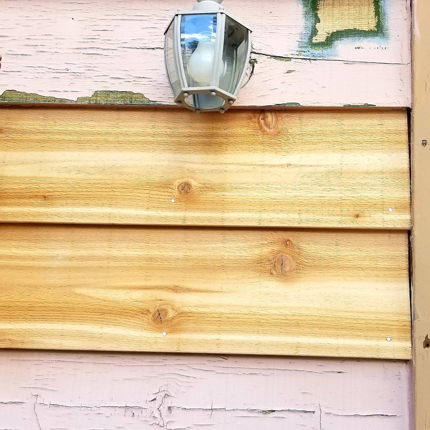 A wooden wall with a light hanging from it