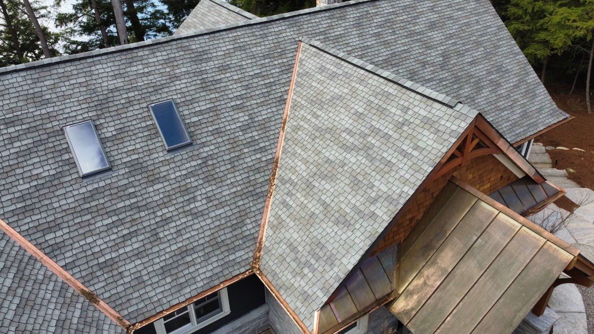 An aerial view of a house with a gray roof and copper trim.
