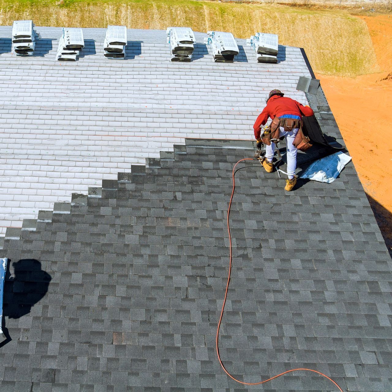 A man is working on the roof of a house.