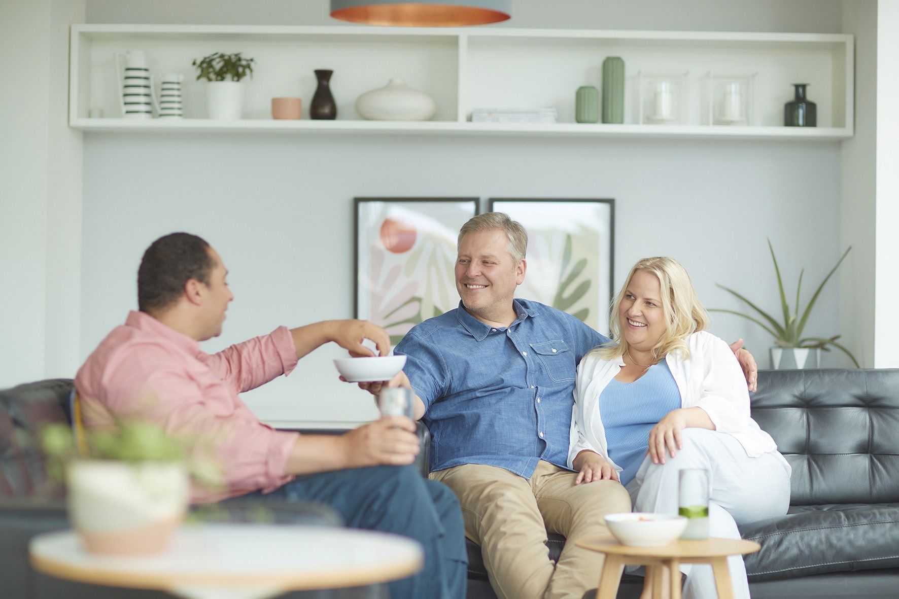 A group of people are sitting on a couch in a living room.