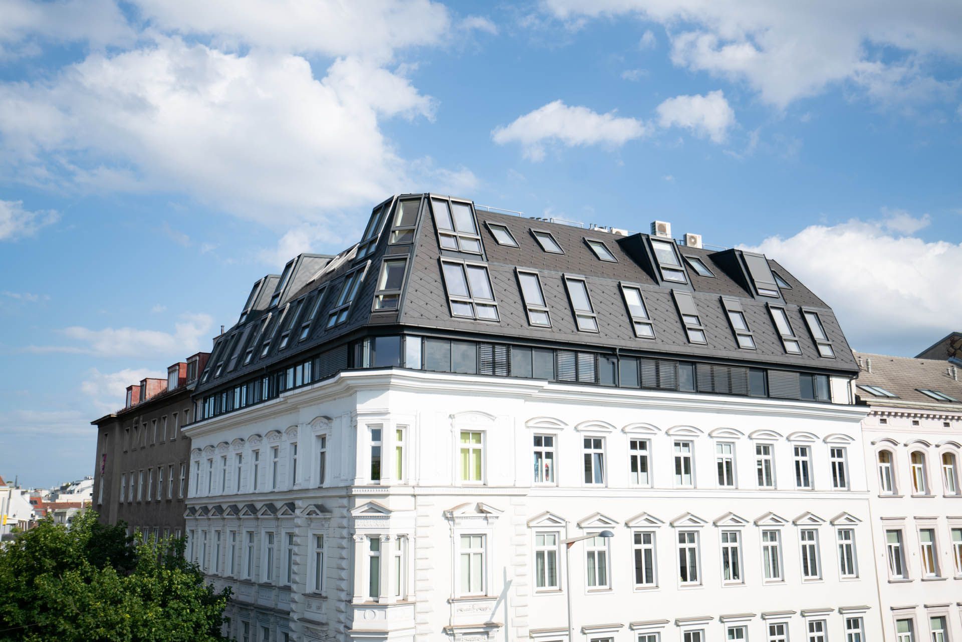 Weißer Altbau unter blauem Himmel