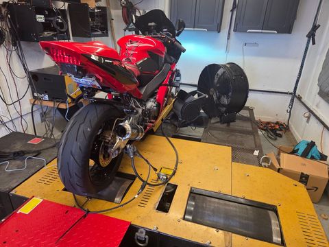 Gloved hands tuning a powersports engine carburetor