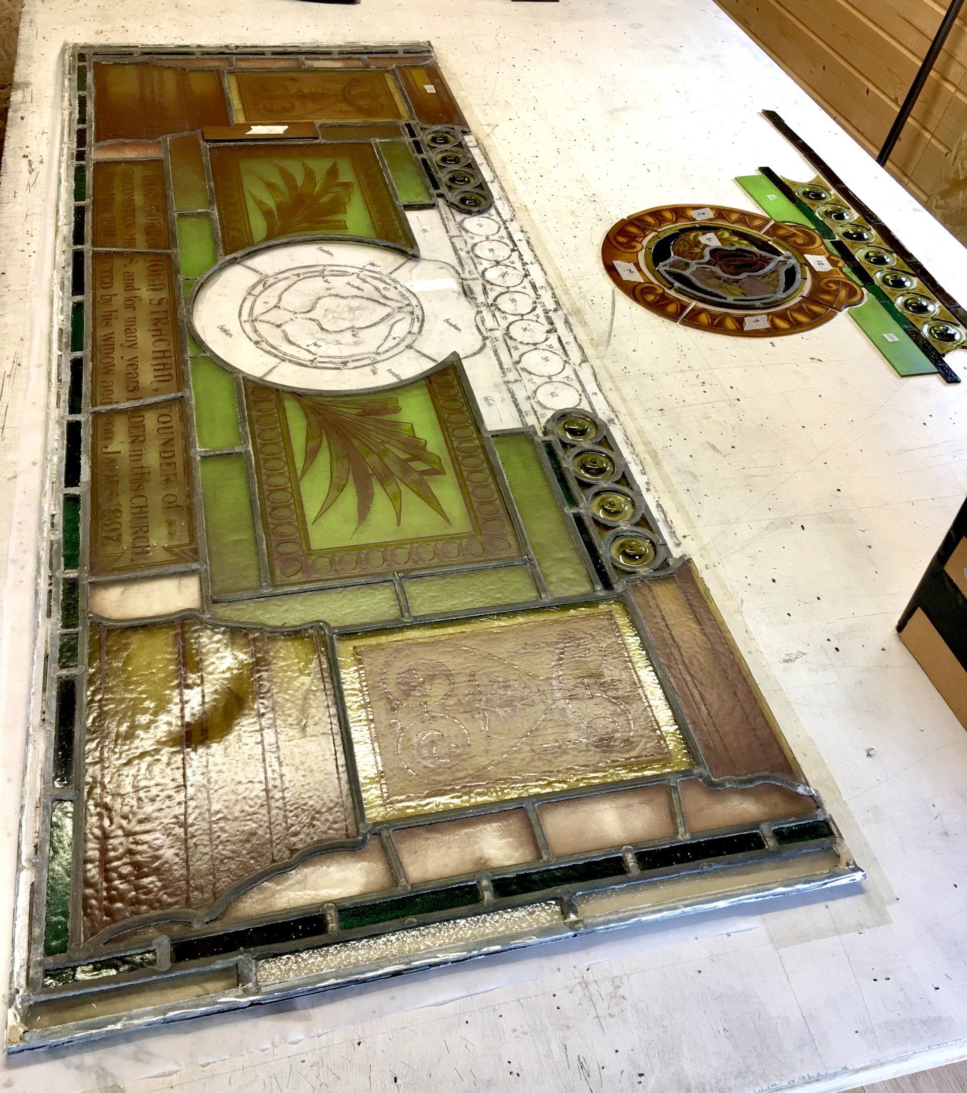 Decorative floor inlay with green and brown patterns, including a circular medallion and palm tree design