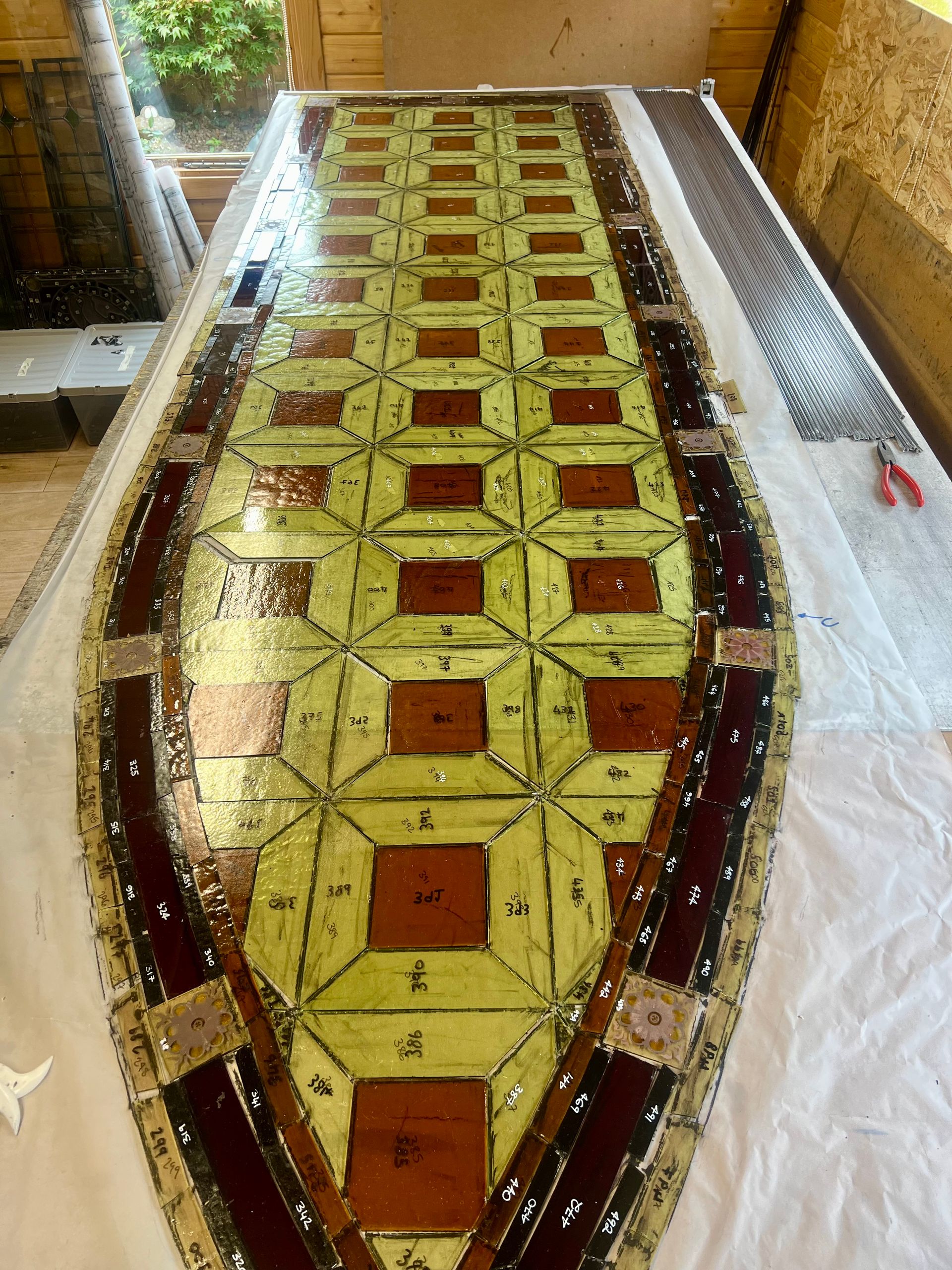Long, narrow mosaic floor with yellow and red geometric tiles inside a hallway or gallery