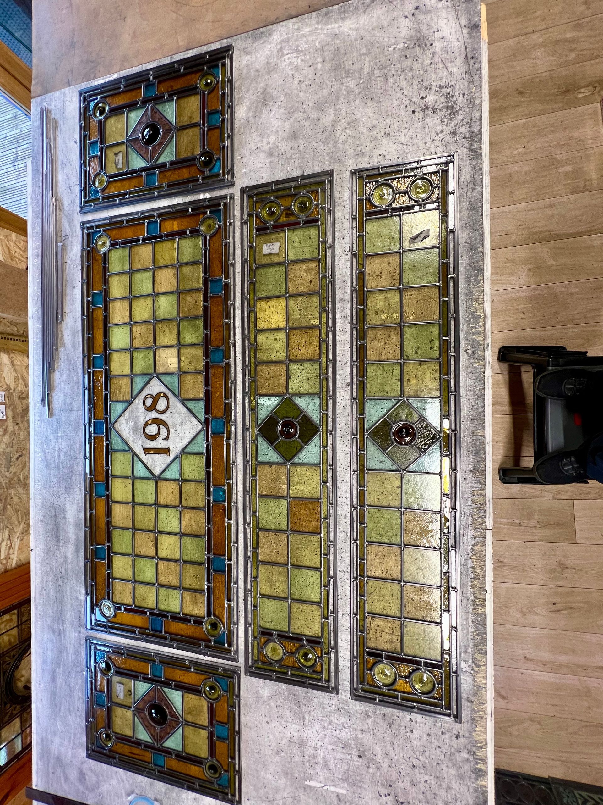 Decorative stained-glass front door with colorful panels and a central “96” plaque