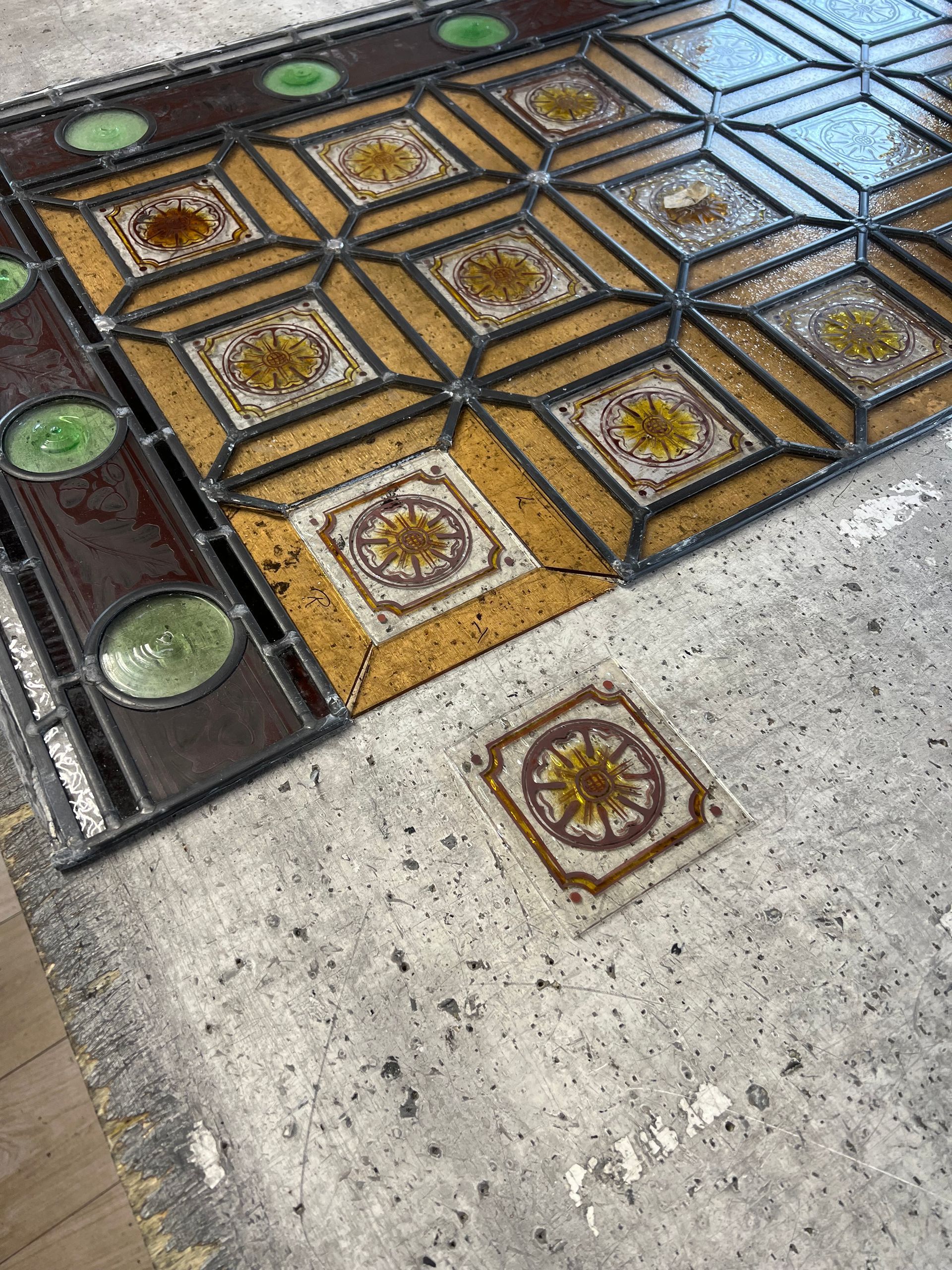 Decorative tiled walkway with geometric brown and gold patterns beside a concrete path