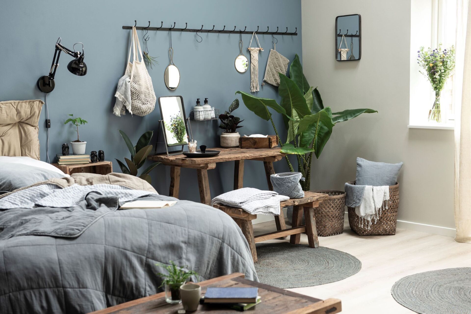Ein Schlafzimmer mit zwei Betten, einem Schreibtisch, einem Tisch und einer Pflanze.