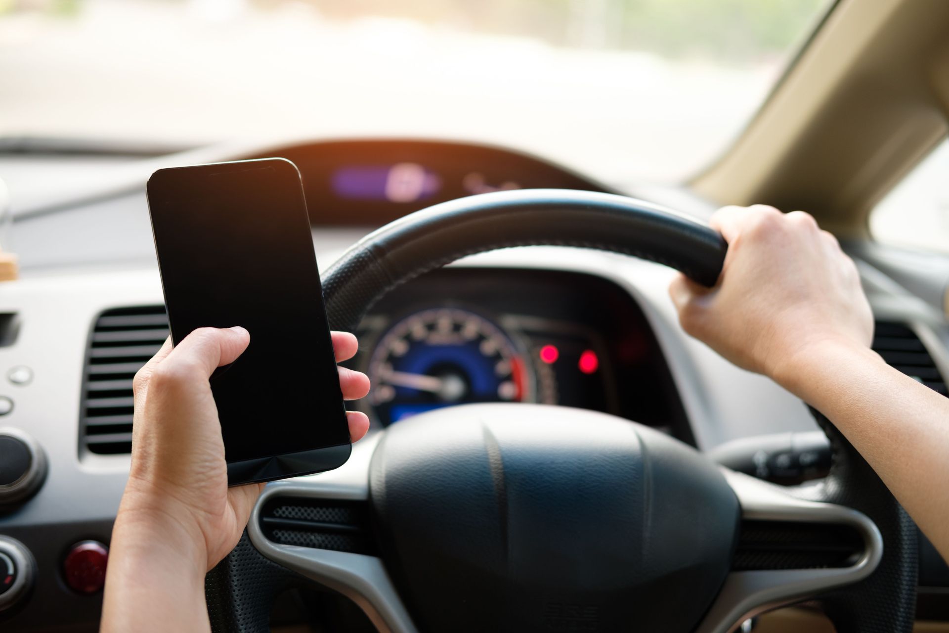 Driver holding a cell phone behind the wheel, illegal under Pennsylvania's Paul Miller's Law