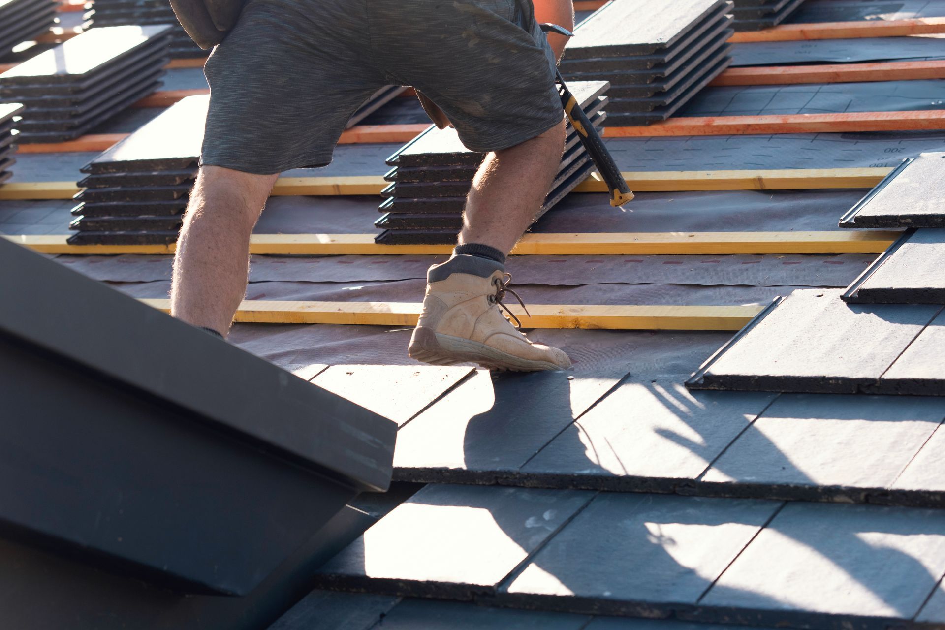 Professional Siding Company in Ohio and Kentucky Worker standing on a slate roof during roof installation