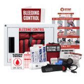 A white wall-mounted bleeding control station kit with medical supplies, tourniquets, and emergency instructional posters.