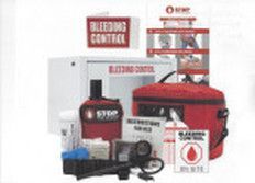 A red and white emergency bleeding control kit with supplies, including a tourniquet, bandages, and a wall-mounted cabinet.