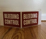 Two white rectangular stickers with red borders and backgrounds, each reading