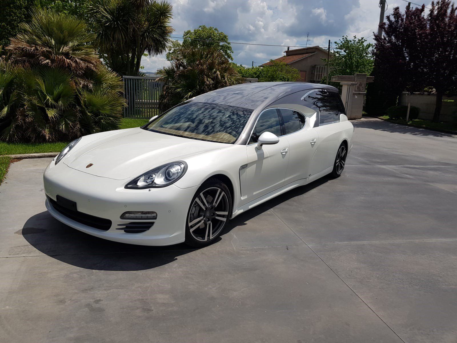 Carro funebre Porsche bianco parcheggiato.