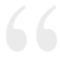 A pair of white quotation marks on a white background.