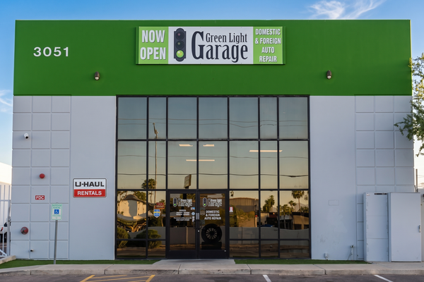 Storefront of Green Light Garage with a green facade and large glass entrance doors.