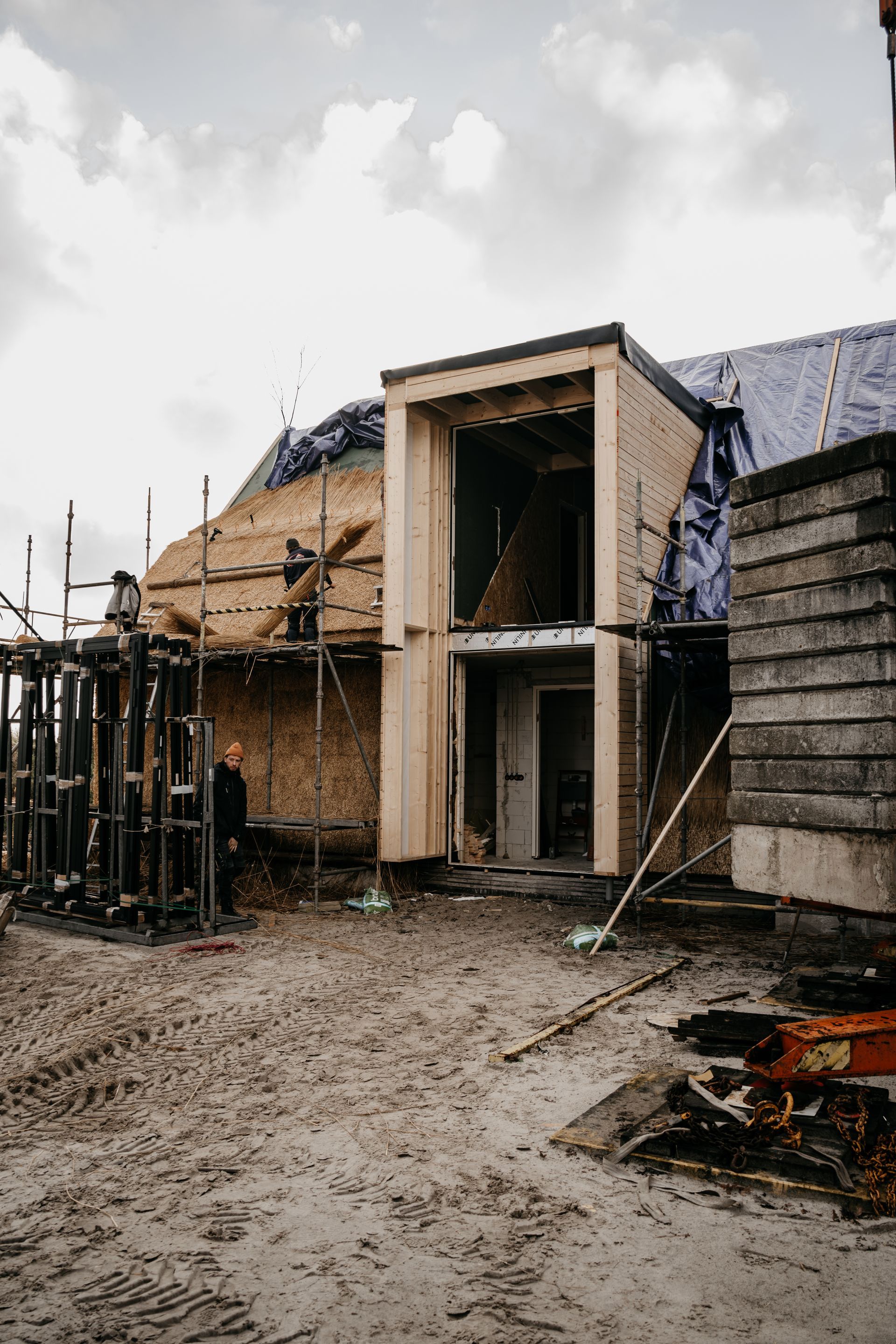 Een houten gebouw wordt gebouwd in een veld van zand.